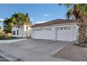 Charming white home with a three-car garage, well-maintained landscaping and a beautiful red tile roof at 16662 S 37Th Way, Phoenix, AZ 85048