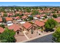 Overhead view of a residential community with homes, mature trees, streets, and mountain views in the background at 1910 E Citation Ln, Tempe, AZ 85284