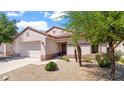 Charming single-story home with desert landscaping, a tile roof, and an attached two-car garage at 19523 N Carriage Ln, Surprise, AZ 85374