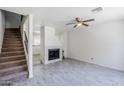 Spacious living room with a cozy fireplace, neutral color scheme, and staircase at 1961 N Hartford St # 1055, Chandler, AZ 85225