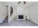 Bright living room featuring a fireplace, ceiling fan, and staircase leading to the upper level at 1961 N Hartford St # 1055, Chandler, AZ 85225