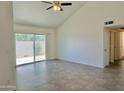 Bright living room featuring neutral paint, tile flooring, sliding glass doors, and a ceiling fan at 2100 W Lemon Tree Pl # 59, Chandler, AZ 85224