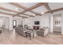 Elegant living room with hardwood floors, wood beam ceilings, and white accent wall at 23126 N 45Th Pl, Phoenix, AZ 85050