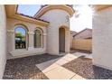 Inviting front entrance with rounded features, tiled walkway, and landscaped bed at 27105 W Marco Polo Rd, Buckeye, AZ 85396