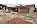 Charming single-story home featuring desert landscaping, a palm tree and a two car garage at 3021 E Shangri La Rd, Phoenix, AZ 85028