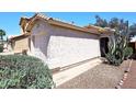 Home's exterior showcasing desert landscaping, a pathway, and neutral stucco walls at 3122 E Kristal Way, Phoenix, AZ 85050