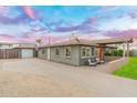 An inviting home exterior featuring a spacious driveway and charming outdoor seating area at 717 E Palmaire Ave, Phoenix, AZ 85020