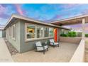 Charming home featuring an inviting front porch with stylish seating and a vibrant orange door at 717 E Palmaire Ave, Phoenix, AZ 85020