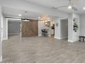 Spacious living area featuring tile floors, a barn door, and an adjacent kitchen with a breakfast bar at 717 E Palmaire Ave, Phoenix, AZ 85020