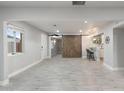 Open living area features tile floors, stylish barn door, and a breakfast bar connecting to the kitchen at 717 E Palmaire Ave, Phoenix, AZ 85020