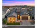 Beautiful home boasts a three-car garage, manicured lawn, and charming covered porch at 8149 E Jaeger St, Mesa, AZ 85207