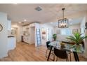 Open-concept interior boasting a glass dining table, modern light fixture, and sleek flooring at 832 S Drew St, Mesa, AZ 85210