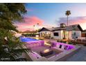 Resort-style backyard features pool, bar seating, fire pit, and lounge area with outdoor TV for ultimate relaxation at 8734 E Amelia Ave, Scottsdale, AZ 85251