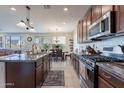 Spacious kitchen boasts a center island, stainless steel appliances, dark wood cabinets and granite countertops at 10035 E Trent Ave, Mesa, AZ 85212