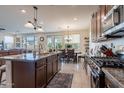 Open concept kitchen featuring stainless steel appliances, dark cabinets and a spacious dining area at 10035 E Trent Ave, Mesa, AZ 85212