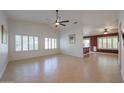 Bright living room with neutral tile flooring, plantation shutters and a ceiling fan at 10371 W Pontiac Dr, Peoria, AZ 85382