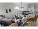 Bright living room featuring wood floors, a ceiling fan, and a fireplace with a shiplap accent wall at 10733 W Clover Way, Avondale, AZ 85392
