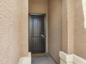 A covered front entry showcasing a secure metal screened front door with a welcome mat at the threshold at 10743 W Bronco Trl, Peoria, AZ 85383