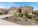 Charming single-story home featuring a desert landscaped front yard and an attached two car garage at 10743 W Bronco Trl, Peoria, AZ 85383