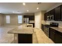 Modern kitchen featuring stainless steel appliances, dark cabinets, and a granite countertop island at 10743 W Bronco Trl, Peoria, AZ 85383