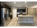 Modern kitchen featuring stainless steel appliances, dark cabinets, and a granite countertop island at 10743 W Bronco Trl, Peoria, AZ 85383