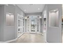 Bright foyer with tile flooring, recessed lighting, art niches, and a decorative glass front door at 11342 E Laguna Azul Cir, Mesa, AZ 85209