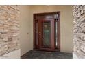 Elegant stone and stucco entryway with a custom-designed metal front door and tiled porch at 11342 E Laguna Azul Cir, Mesa, AZ 85209