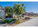 Beautiful single-story home featuring lush landscaping, a brick facade, and a view of neighboring properties at 11656 W Luxton Ln, Avondale, AZ 85323