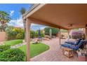 Inviting covered patio with pavers, lush landscaping, rocks, outdoor seating, and lounge chairs, perfect for relaxation and entertaining at 12686 N 95Th Way, Scottsdale, AZ 85260