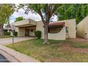 Charming tan home with a covered driveway and a beautifully maintained front yard at 131 N Higley Rd # 51, Mesa, AZ 85205