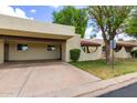 View of a tan single-story home with a covered parking space and tidy landscaping at 131 N Higley Rd # 51, Mesa, AZ 85205
