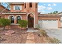 Beautiful home exterior with arched entry, tile roof, and a well-kept front yard with rock landscaping at 14744 W Poinsettia Dr, Surprise, AZ 85379