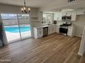 Updated kitchen with white cabinets, stainless steel appliances, quartz countertops, and backyard pool view at 1545 W Marco Polo Rd, Phoenix, AZ 85027