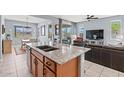 Open-concept kitchen with granite island, stainless steel sink, and seamless flow to dining and living areas at 16139 S 178Th Dr, Goodyear, AZ 85338
