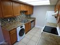 Updated kitchen with stainless steel appliances, modern backsplash, and in-unit laundry at 16602 N 25Th St # 129, Phoenix, AZ 85032