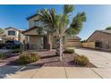 Charming two-story home with desert landscaping, a front porch, and a long driveway leading to a two-car garage at 18096 N Arbor Dr, Maricopa, AZ 85138