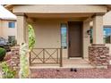 Inviting front porch with stone accents and desert landscaping, enhancing the home's entrance and curb appeal at 18096 N Arbor Dr, Maricopa, AZ 85138