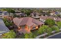 Expansive aerial view showcases a neighborhood home with a tile roof, lush landscaping, and paved driveway at 20546 W Summit Pl, Buckeye, AZ 85396