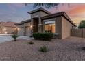 Exterior shot of home featuring desert landscaping and a view of the three-car garage at 22166 N Lakeside Dr, Maricopa, AZ 85138