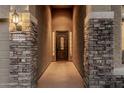 Close-up of the front door framed by stone pillars with accent lighting at 22166 N Lakeside Dr, Maricopa, AZ 85138