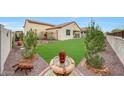 Lush backyard featuring a well-maintained lawn, desert landscaping, and a charming water feature at 22282 N 184Th Ln, Surprise, AZ 85387