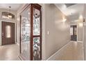Bright entryway featuring tile floors, display case, and neutral paint, with views of the front door at 22683 N Aaron Rd, Maricopa, AZ 85138