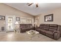 Inviting living room featuring tile flooring, neutral walls, and comfortable brown leather sofas at 22683 N Aaron Rd, Maricopa, AZ 85138