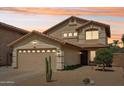 Sunset view of a charming two-story home with desert landscaping and a two-car garage at 2306 E Parkside Ln, Phoenix, AZ 85024