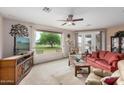 Bright living room featuring a large picture window with views of the outdoors, a ceiling fan, and comfortable seating at 2662 S Springwood Blvd # 462, Mesa, AZ 85209