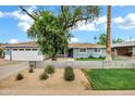 Charming home with well-kept landscaping, blue painted exterior, and a new garage door at 3046 E Glenrosa Ave, Phoenix, AZ 85016