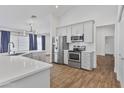 Modern kitchen featuring stainless steel appliances, white cabinets, quartz countertops, and island seating at 4632 E Kachina Trl, Phoenix, AZ 85044