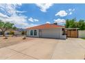 Well-maintained house with a red tile roof, two-car garage and low-maintenance desert landscaping at 4953 W Acoma Dr, Glendale, AZ 85306