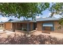 Inviting home featuring blue shutters, brick accents, and a cozy front porch seating area at 5210 W Ironwood Dr, Glendale, AZ 85302