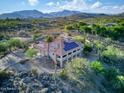 Expansive aerial view of home with tile roof and mountain views, showcasing the desert landscape and solar panels at 6524 E Rockaway Hills Dr, Cave Creek, AZ 85331